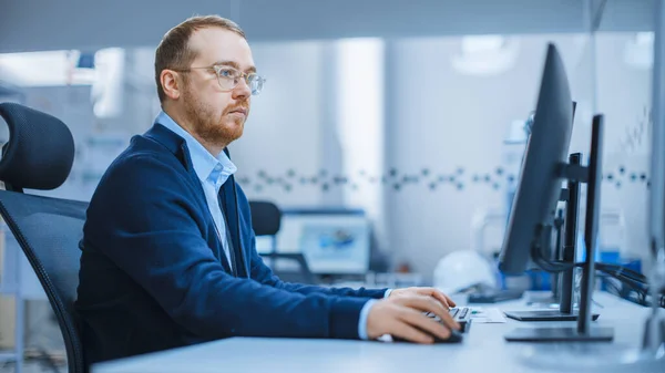 Shot van een Zware Industrie Ingenieur die aan Personal Computer in Moderne Industriële Fabriek met High-Tech CNC Machines werkt — Stockfoto