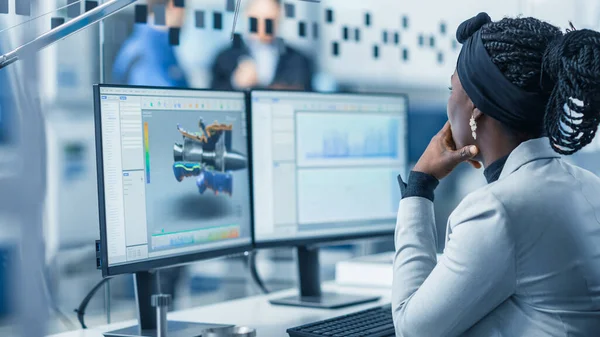 Vacker kvinnlig ingenjör Som arbetar med persondator i den högteknologiska industrifabriken använder hon CAD-programvara för att designa 3D-turbin. Över axeln Skott. — Stockfoto