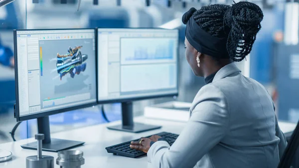 Красивая женщина-инженер, работающая на персональном компьютере на высокотехнологичной промышленной фабрике, использует программное обеспечение САПР при проектировании 3D турбины. Над плечом . — стоковое фото
