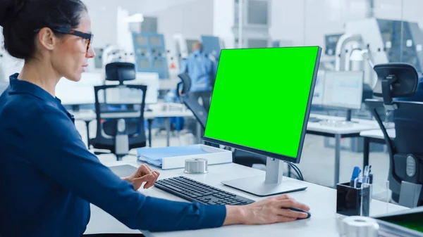 Over the Shoulder: Personal Computer 에서 일하는 여성 수석 엔지니어 , Display 는 Green Mock-up Screen 또는 Chroma Key 이 다. 첨단 기술 기계와 전문 직업인을 위한 산업 공장 — 스톡 사진