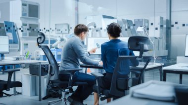 Modern Fabrika: Kadın Proje Yöneticisi, Kişisel Bilgisayar 'da çalışan bir Erkek Endüstriyel Mühendis ile konuşuyor. Yüksek Teknolojik Endüstriyel Malzemelerin Tasarımı ve Geliştirilmesi için CAD Yazılımı kullanıyorlar