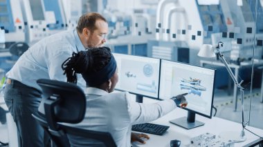 Modern Fabrika: Erkek Proje Yöneticisi Bilgisayar üzerine çalışan kadın bir endüstri mühendisiyle konuşuyor. Tasarım Sıfır Emisyon Motoru için CAD yazılım kullanıyorlar. Yüksek Teknoloji Endüstri Tesisi 'nde çalışıyor.