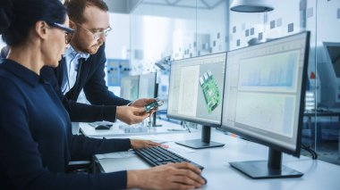 Modern Elektronik Fabrikası: CAD Yazılım ile Bilgisayar üzerine çalışan Kadın Elektrik Mühendisi ile Erkek Denetçi Konuşuyor. PCB, Mikroçipler, Yarı iletkenler ve Telekomünikasyon Ekipmanları Geliştiriliyor