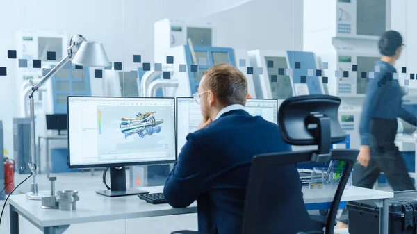 Industrial Engineer Solving Problems, Working on a Personal Computer, Two Monitor Screens Show CAD Software with 3D Prototype of Hybrid Electric Engine being Tested. Pracovní moderní továrna. — Stock fotografie
