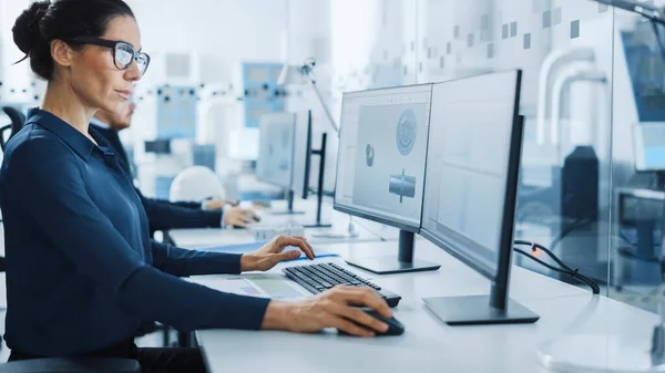 Ingeniero Industrial Resolviendo Problemas, Trabajando en una Computadora Personal, Usando Ratón y Teclado, Dos Pantallas de Monitor Muestran Software CAD con Equipo de Máquina en 3D . — Foto de Stock