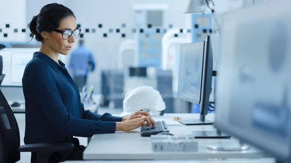 아름다운 여성 엔지니어는 하이테크 산업 공장에서 개인용 컴퓨터를 연구하고 있으며, 그녀는 CAD 소프트웨어를 모델 헤비 산업 첨단 기술 기계 장치 3D 모델에 사용 한다. 사이드 뷰 샷 — 스톡 사진