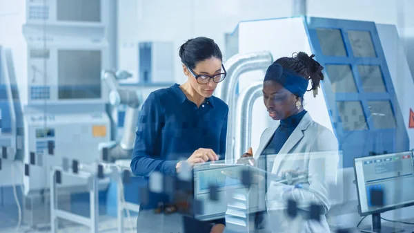 Ingénieur industriel parle avec le superviseur de projet, Ils utilisent un ordinateur tablette numérique et discuter de la planification d'usine moderne. Installation de fabrication avec machines CNC et chaîne d'assemblage de bras de robot — Photo