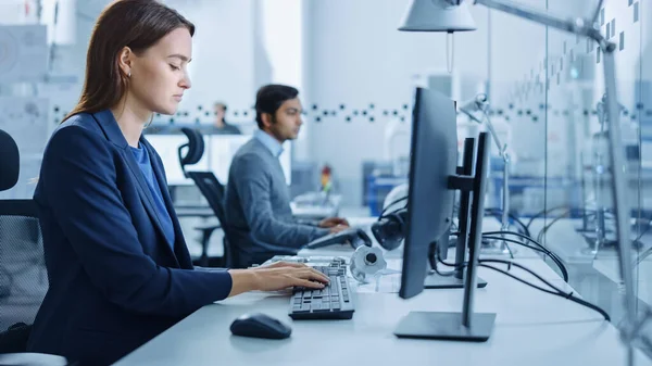 Porträt eines jungen und selbstbewussten Wirtschaftsingenieurs, der am Computer arbeitet. Industrielle Fabrik mit High-Tech CNC-Maschinen — Stockfoto