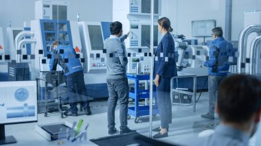 Modern Fabrika Ofisi: Bilgisayar üzerine çalışan Endüstriyel Mühendisler Ekibi. Fabrika Atölyesinde: Profesyonel İşçiler Yüksek Teknoloji Endüstriyel CNC Makinesi, Program Robot Kolu, Toplantı Kullanıyor.