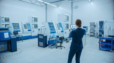 Modern Fabrika: Kadın Mühendis Yer Haritalama için Görselleştirme Atölyesi için Artırılmış Gerçeklik Yazılımı ile Dijital Tablet Bilgisayar kullanıyor. Yüksek teknolojili CNC Makineleri ve Robot Kollu Tesis