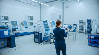 Modern Fabrika: Kadın Mühendis Yer Haritalama için Görselleştirme Atölyesi için Artırılmış Gerçeklik Yazılımı ile Dijital Tablet Bilgisayar kullanıyor. Yüksek teknolojili CNC Makineleri ve Robot Kollu Tesis