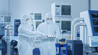 Steril Modern Fabrika: Örtüler, Maskeler Atölyede Yürür ve Konuşur Profesyonelleri. Yüksek Teknoloji CNC Makineleri ile Tıbbi Elektronik Üretim Laboratuvarı, Robot Arm Üretim Hattı.