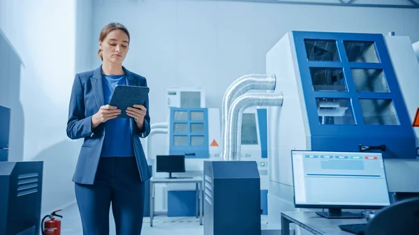 " Modern Factory: Confident Female Engineer Walks Through Facility, Holding Laptop, Επιθεώρηση και Παρακολούθηση Εργαστήρι Workings. Κατασκευή έχει επαγγελματίες που εργάζονται σε CNC μηχανήματα, βραχίονα ρομπότ" — Φωτογραφία Αρχείου