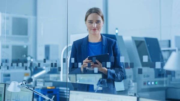 Modern Factory Office: Portrait of Young and Confident Female Industrial Engineer Standing and Holding Digital Tablet, She Smiles Charmingly at Camera Промисловий завод з ЧПУ верстат — стокове фото