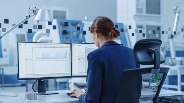 Retrato de Jovem e Confiante Engenheiro Industrial Trabalhando no Computador, na Tela CAD Software Mostrando Nova Geração Motor Elétrico. Fábrica industrial com máquinas CNC de alta tecnologia . — Fotografia de Stock