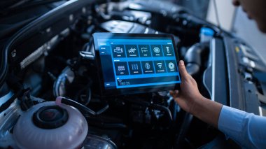 Araba Servisi Yöneticisi veya Tamircisi, Geleceğsel Etkileşimli Tanılama Yazılımlı Tablet Bilgisayar Kullanır. Uzman, Motor Koyu 'nda Kırık Bileşenleri Bulmak İçin Araç İnceleme Yapıyor.