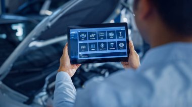 Araba Servisi Yöneticisi veya Tamircisi, Geleceğsel Etkileşimli Tanılama Yazılımlı Tablet Bilgisayar Kullanır. Uzman, Motor Koyu 'nda Kırık Bileşenleri Bulmak İçin Araç İnceleme Yapıyor.