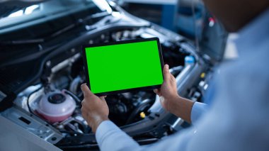 Araba Servisi Müdürü veya Tamircisi, Mühendis Koyu 'nu gösteren yeşil ekran maketli Tablet Bilgisayar kullanır. Motordaki Kırık Bileşenleri Bulma Yolundaki Aracı İnceleme Uzmanı