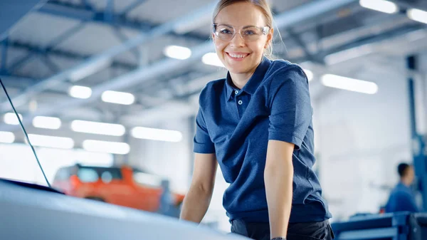 Belo empoderamento feminino carro mecânico está posando em um serviço de carro. Ela usa óculos de segurança. Especialista olha para uma câmera e sorri . — Fotografia de Stock