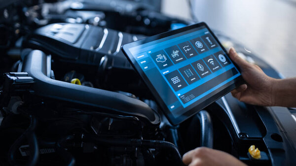 Car Service Manager or Mechanic Uses a Tablet Computer with a Futuristic Interactive Diagnostics Software. Specialist Inspecting the Vehicle in Order to Find Broken Components In the Engine Bay.