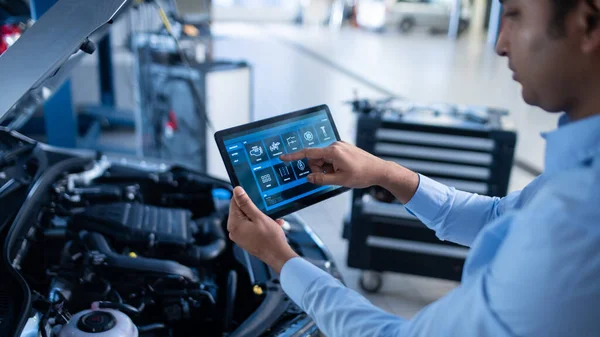 Car Service Manager 또는 Mechanic 은 Futuristic Interactive Diagnostics Software 를 갖춘 태블릿 컴퓨터를 사용 한다. 엔진 만에서 부서진 부품을 찾기 위해 주문에 따라 차량을 검사하는 전문가. — 스톡 사진
