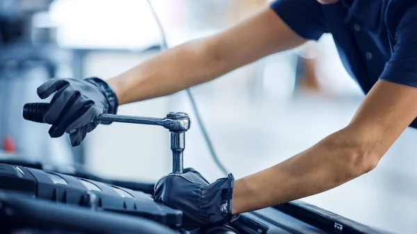 Närbild Skott av en kvinnlig mekaniker som arbetar på ett fordon i en bil service. Stärker kvinnan Fixar motorn. Hon använder en Ratchet. Modern Clean Workshop. — Stockfoto