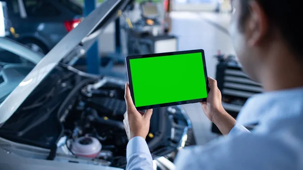 Manažer autoservisu nebo mechanik používá Tablet počítač s Green Screen Fock Up, který je ukázal na Enginer Bay. Specialista na kontrolu vozidla s cílem najít rozbité komponenty v motoru — Stock fotografie