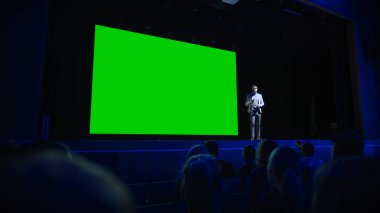 Keynote Sözcüsü, Seyirciye Yeni Ürün, Onun Arkasında Yeşil Ekran, Model, Chroma Key ile Sinema Salonu 'nu Duyuruyor. İş Konferansı Canlı Olay veya Aygıt Açıklaması