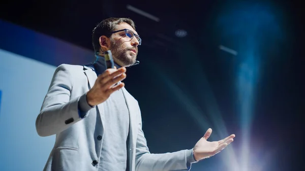 Portrait of Motivational Speaker, Talking about Happiness, Self, Success, Empowerment, Efficiency and How to Be More Productive Self. Large Conference Hall with Cinematographic Light.