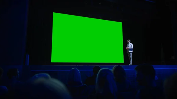 Orador principal anuncia nuevo producto a la audiencia, Detrás de él cine con pantalla verde, Mock-up, Chroma Key. Conferencia de negocios Evento en vivo o revelación de dispositivos —  Fotos de Stock