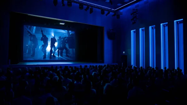 En el cine cautivó a la audiencia viendo una nueva película de éxito de taquilla con soldados militares . — Foto de Stock
