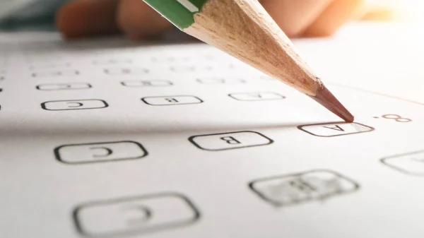 Bei der Prüfung färbt Testperson die richtigen Antworten mit einem Bleistift. Füllen des Antwortbogens mit standardisierten Tests, Markieren korrekter Antwortblasen — Stockfoto