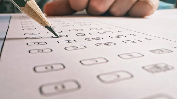 On Exam Test Person Colors Right Answers with a Pencil. Filling up Answer Sheet with Standardized Tests, Marking Correct Answer Bubbles — Stock Photo, Image