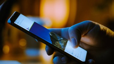 Yakın plan Macro: İnsan Tutma ve Akıllı Telefon Kullanma, Sosyal Ağ Duvarındaki Resimlere Bakma. Parmak Kaydırma Sosyal Medya Uygulaması: Seyahat, Hayvanlar, Yiyecek. Model Uygulama Tasarımı