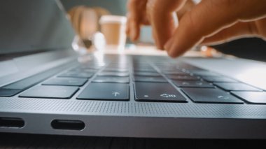 Hareketli Makro Çekim: Laptop Klavyesinde Yazan Kişi. Çalışmak, e-posta yazmak, internet kullanmak. Not Defteri Masada, Parlak Güneşli Gün Arkaplanda