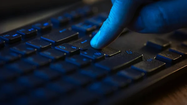 Макросъемка крупным планом: человек, использующий клавиатуру черного компьютера, нажимающий кнопку Enter Confidently. Работа, написание электронных писем, использование Интернета. Темные и зеленые цвета — стоковое фото