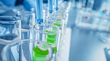İlaç Laboratuvarı: Birden fazla Pipette Mavi Sıvıyı Test Tüplerine Bırakıyor, Tıbbi Araştırma ve Analiz. Ürün Hattı Bırakan DNA çalışması için örnek tüpleri dolduruyor. Makro 'yu yakın plan