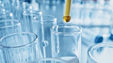 İlaç Laboratuvarı, Pipette Damlayan Sarı Sıvı Test Tüpleri, Tıbbi Araştırma, Analiz. Bilimsel Laboratuar Düşürücü, örnek tüpleri yenilikçi DNA Çalışması Çözümü ile dolduruyor. Makro 'yu yakın plan