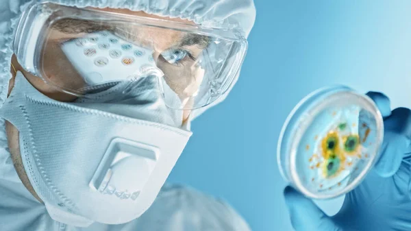 Forskare bär respirator Mask, Coverall och säkerhetsglas ser på Petri maträtter med bakterier, vävnad och blodprov. Medicinsk forskning Laboratorium bota Epidemiska sjukdomar. Närbild Makro — Stockfoto
