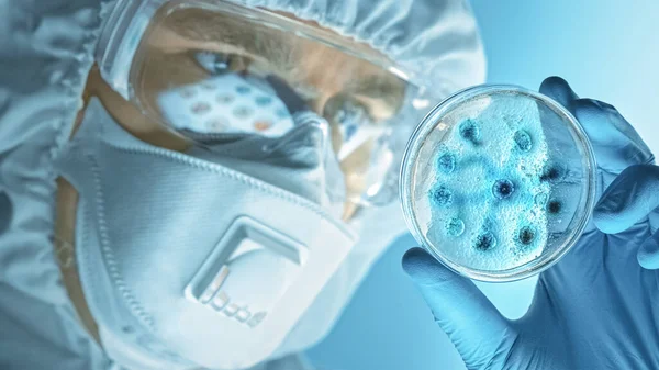 Wetenschapper dragen van Ademhalingsmasker, Coverall en veiligheidsbril kijkt naar petrischalen met bacteriën, weefsel en bloedmonsters. Medisch Onderzoek Laboratorium genezen Epidemische ziekten. Voorgrond Macro — Stockfoto