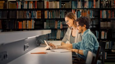 Üniversite Kütüphanesi: Güzel Öğrenci Çifti Tartışıyor, Laptop Kullan, Sınavlara Birlikte Hazırlan, Kağıt Ödevi Konularına Yardım, Araştırma Dersleri.