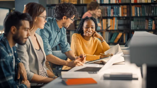 Biblioteka Uniwersytecka: Różnorodna grupa utalentowanych studentów Dyskusja, wykorzystanie laptopa, Przygotowanie do egzaminów razem, Pomaganie, Badając tematy do przydziału papieru. Szczęśliwi młodzi ludzie Badanie na przyszłość — Zdjęcie stockowe