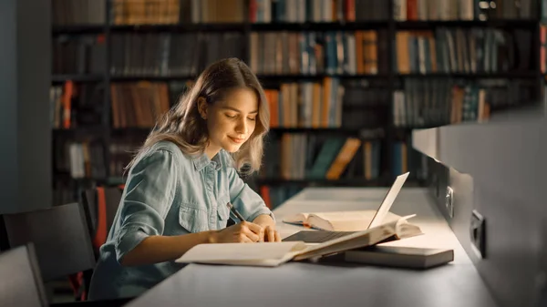 Universitetsbiblioteket: Vacker smart vit flicka använder laptop, skriver anteckningar för papper, Uppsats, Studera för klass uppdrag. Fokuserade studenter Lärande, Studera för College Tentor. Sidovy Porträtt — Stockfoto