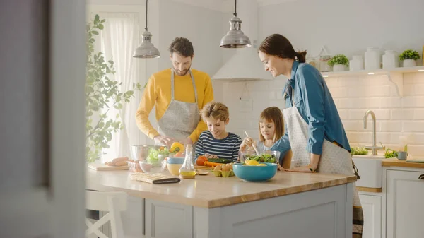 In Kitchen: Family of Four Cooking Together Healthy Dinner. Mother, Father, Little Boy and Girl, Preparing Salads, Washing and Cutting Vegetables. Cute Children Helping their Beautiful Caring Parents — Stock Photo, Image