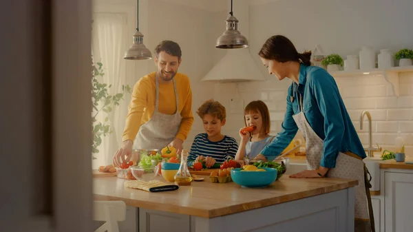 In Kitchen: Family of Four Cooking Together Healthy Dinner. Mother, Father, Little Boy and Girl, Preparing Salads, Washing and Cutting Vegetables. Cute Children Helping their Beautiful Caring Parents — Stock Photo, Image