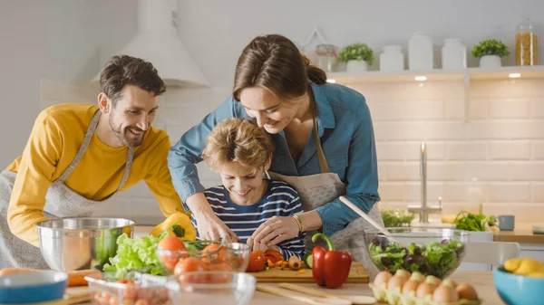 In Kitchen: Family of Three Cooking Together Healthy Dinner. Mother and Fathe Teach Little Boy Healthy Habits and to Cut Vegetables for Dinner Salad. Cute Child Helping their Beautiful Caring Parents — Stock Photo, Image