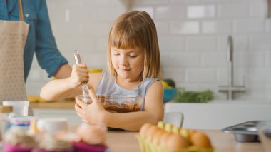 Mutfakta: Kekler için Hamur Hamuru yaratmak için Un ve Suyu Karıştıran Şirin Küçük Kızın Portresi. Birlikte Aile Kekleri Pişiriyoruz. Sevimli Çocuklar Bakıcı Ailelerine Yardım Ediyor