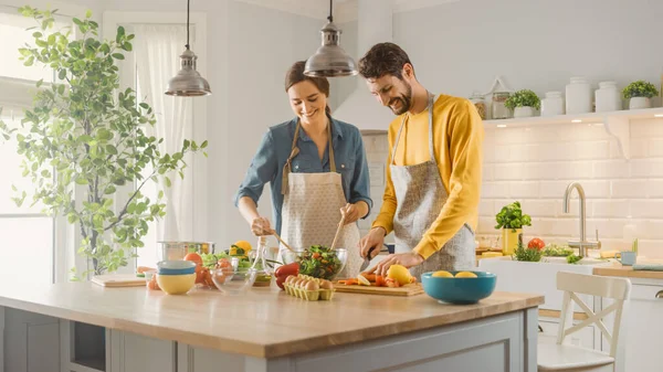 I köket: Perfekt glada par förbereda hälsosam mat, massor av grönsaker. Man Jonglerar med frukt, får sin flickvän att skratta. Härliga människor i kärlek ha kul — Stockfoto