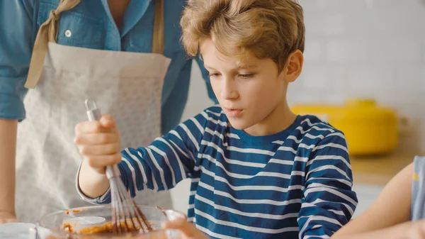 In the Kitchen: Portrait of the Cute Smart Boy Mixing Flour and Water to Create Dough for Cupcakes. Family Cooking Muffins Together. Adorable Children Helping their Caring Parents — Stock Photo, Image