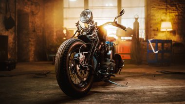 Custom Bobber Motorbike Standing in an Authentic Creative Workshop. Vintage Style Motorcycle Under Warm Lamp Light in a Garage. clipart